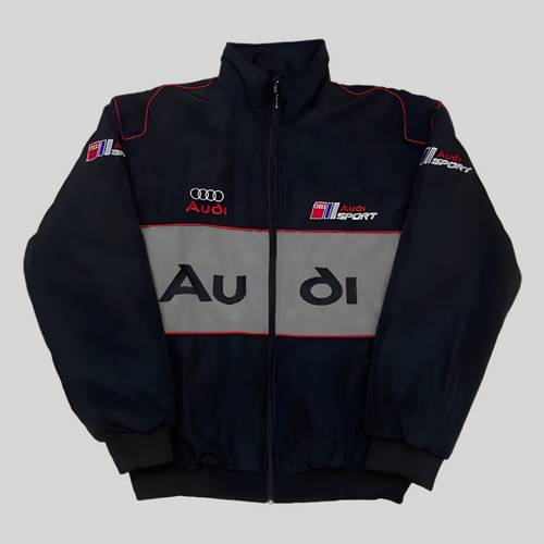 A black Audi racing jacket with red and gray embroidery, featuring the Audi logo and sport branding.